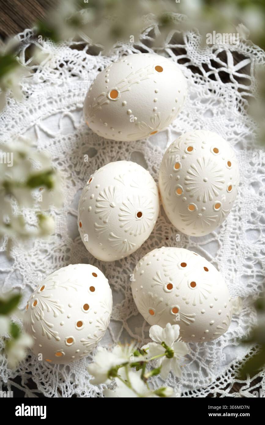 White Easter eggs decorated with wax, with cherry blossoms in spring Stock Photo