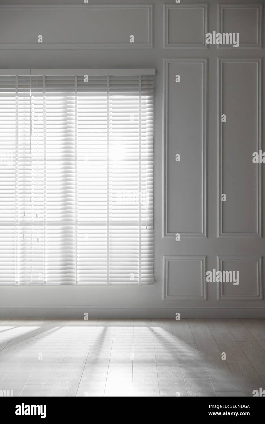 Sun shining through window blinds in light room Stock Photo