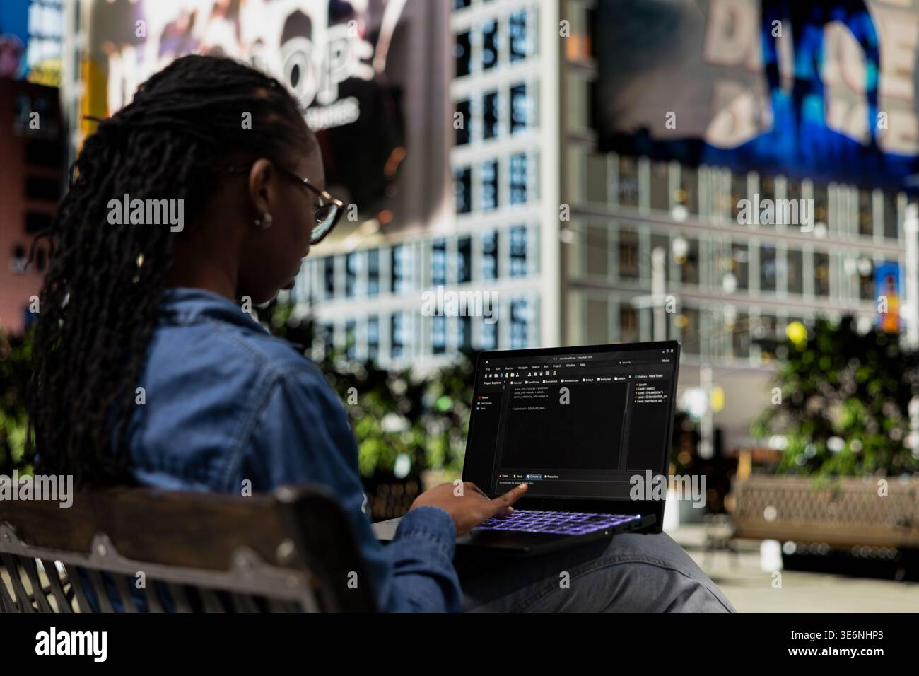 Software developer on park bench writes code on laptop, implementing algorithms. Female programmer using programming languages script program on notebook display, freelancing outdoors Stock Photo
