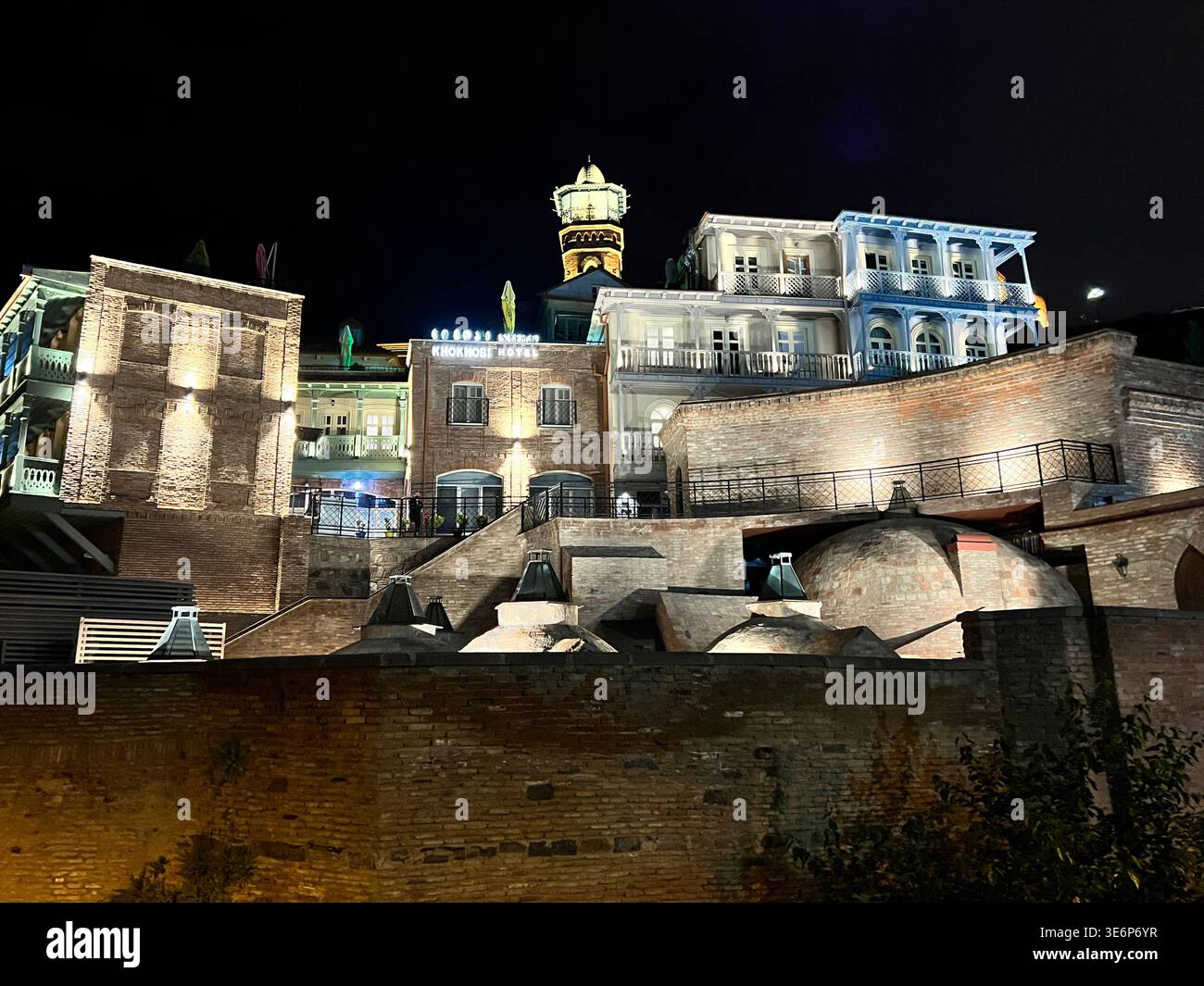 Illuminated sulfur bath domes and old town buildings at night in Abanotubani, Tbilisi, Georgia. - Smartphone Captured Stock Image