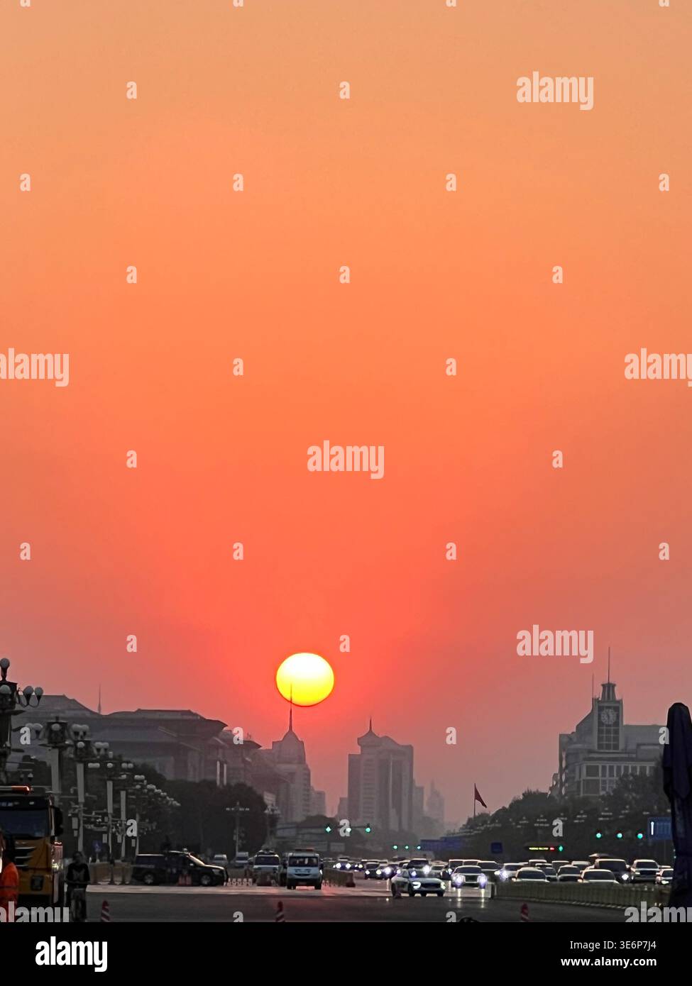 Sunset over a broad city avenue with evening traffic and urban skyline in Beijing, China. Stock Photo