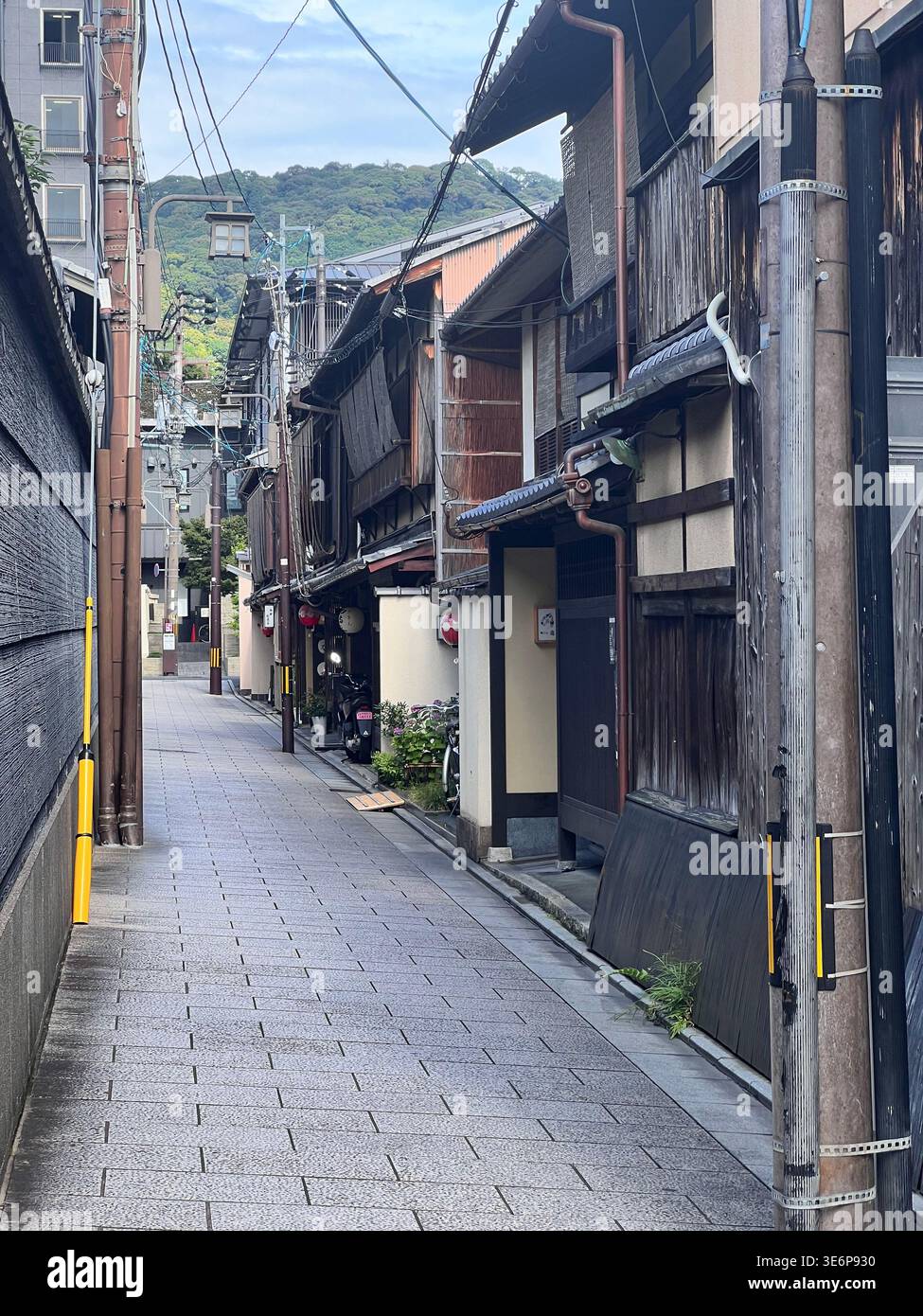 Narrow stone-paved alley lined with traditional buildings in Kyoto, Japan. Stock Photo