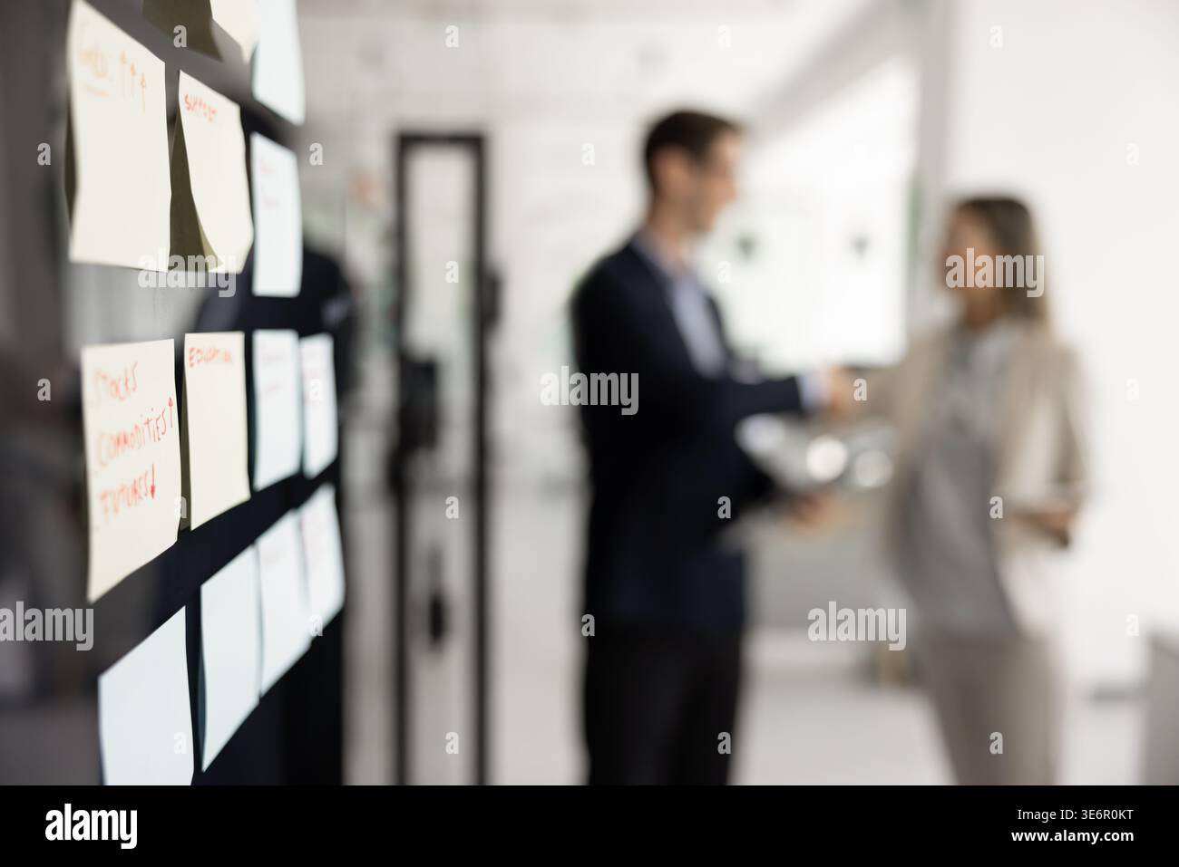 Close-up sticky notes on glass wall, filled with handwritten reminders Stock Photo