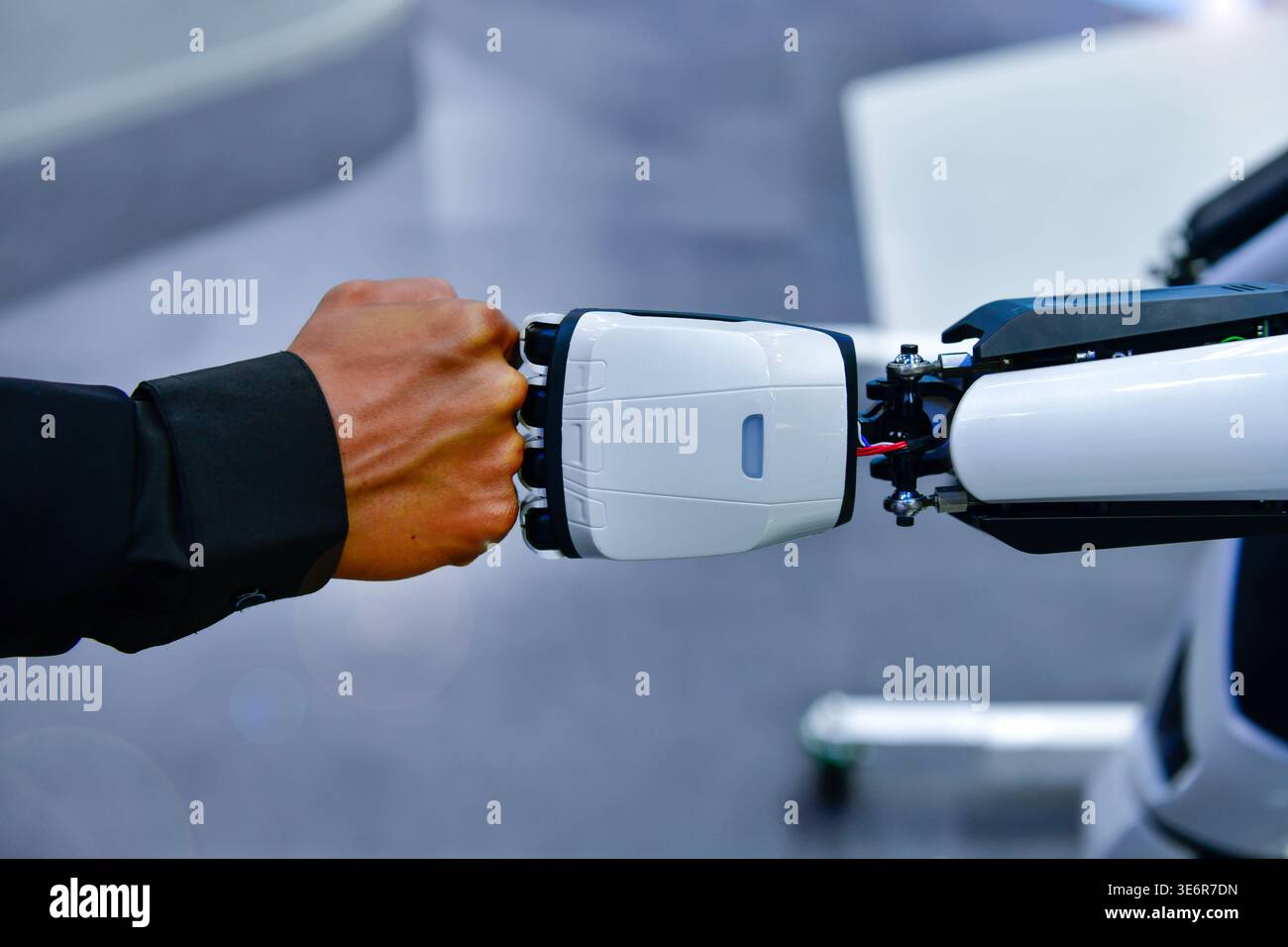Human and robot fist bump against digital network background, representing future collaboration between man and artificial intelligence Stock Photo