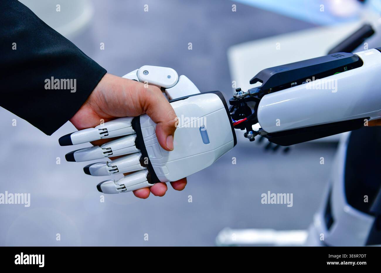 Robot and human handshake representing artificial intelligence collaboration and future technology. Stock Photo