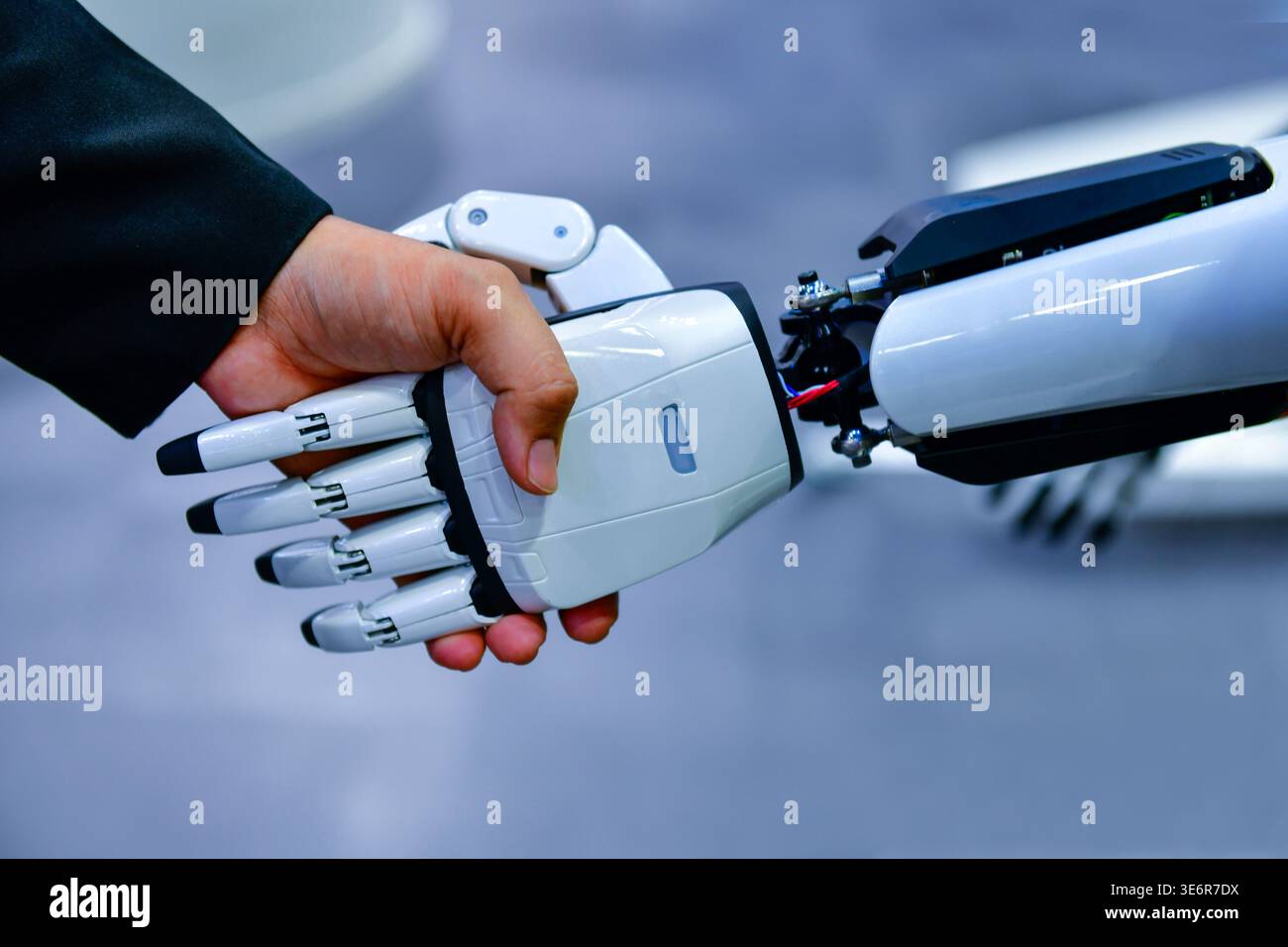 Robot and human handshake representing artificial intelligence collaboration and future technology. Stock Photo