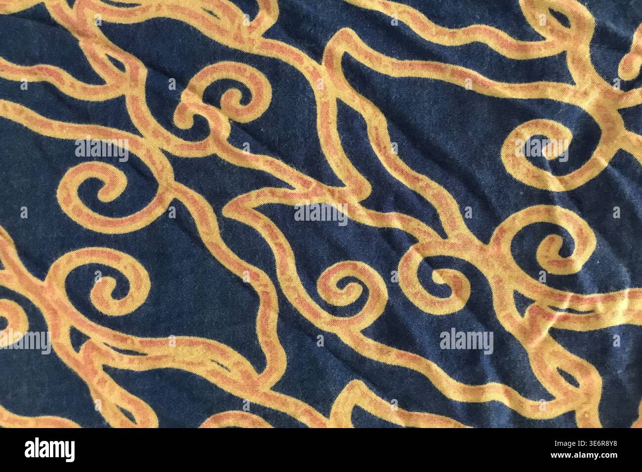 Dark blue fabric features swirling golden patterns Stock Photo