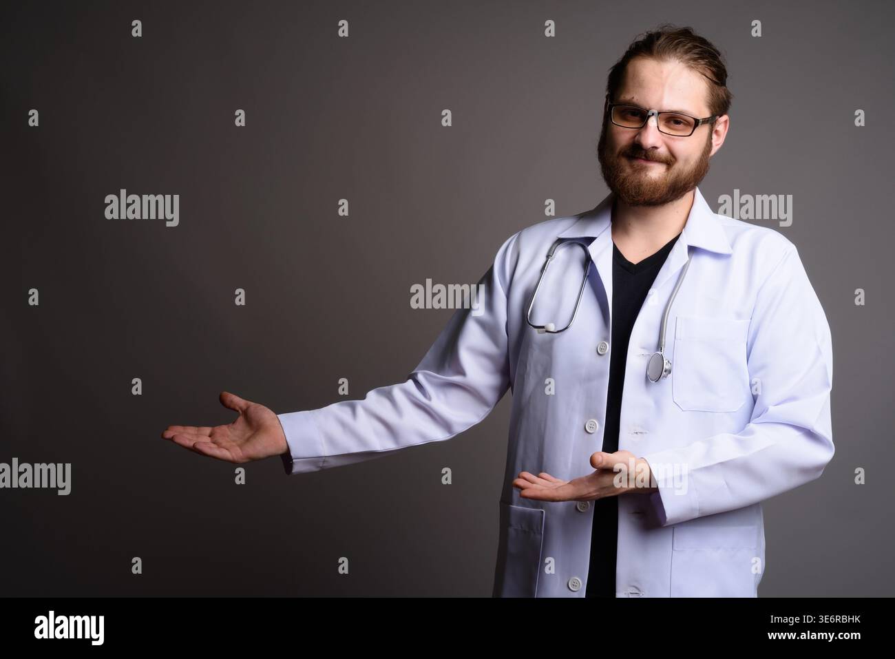 Studio portrait of a smiling bearded male doctor in a white lab coat ...