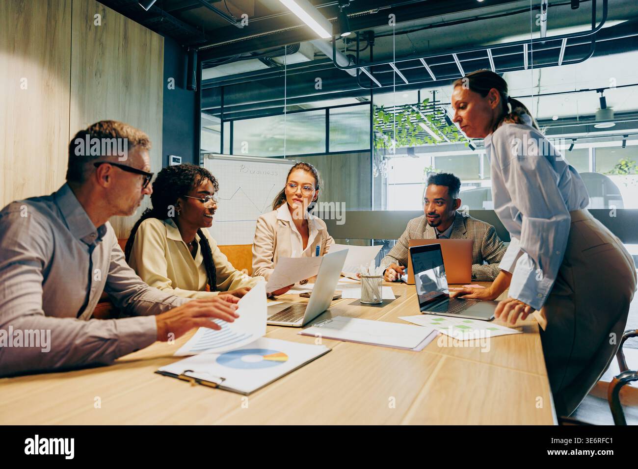 Team engaged in lively discussion analyzing data and planning ahead Stock Photo