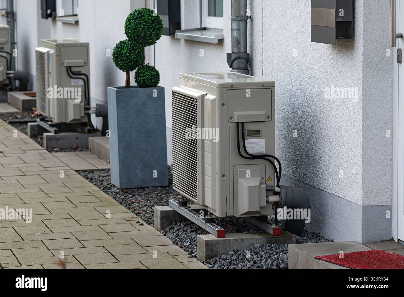 Air conditioning units are placed beside a building in an urban area ...