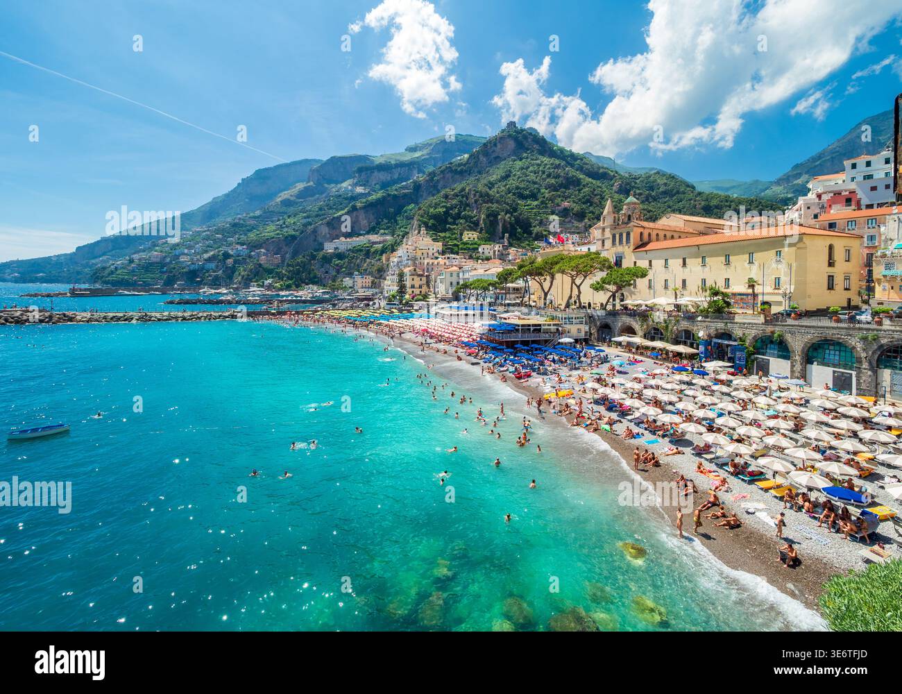 Crowded beach with people swimming and sunbathing under umbrellas on a ...