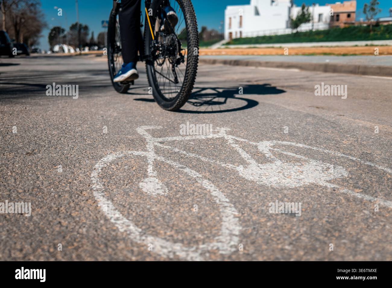 Cyclist riding bicycle on a dedicated asphalt bike path marked with a ...