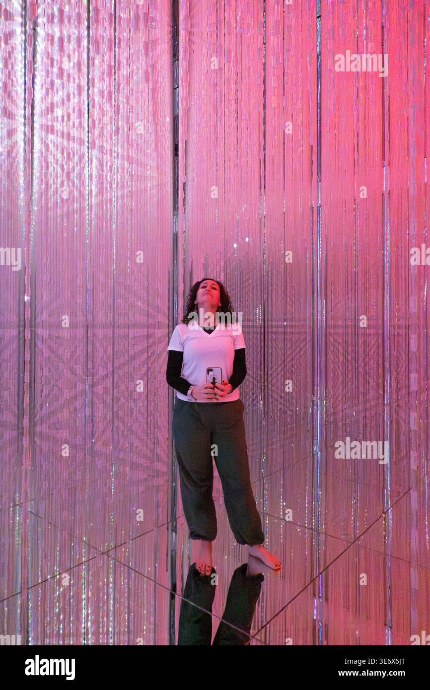 Teamlab Lighting A visitor walks through cascading LED light strands inside an immersive ...