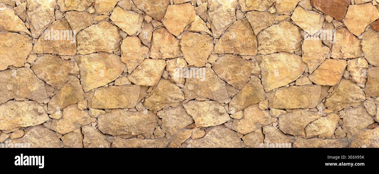 Rough stone wall featuring natural rocks creating a textured background Stock Photo