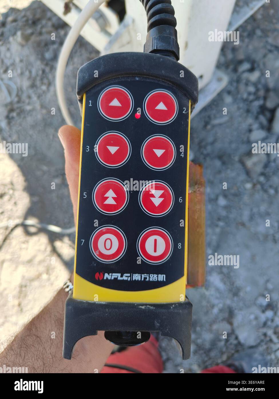 Close-up of a handheld remote control unit for operating NFLG NFS 350 industrial machinery. Detail of buttons in Algeria. - Smartphone Captured Stock Image