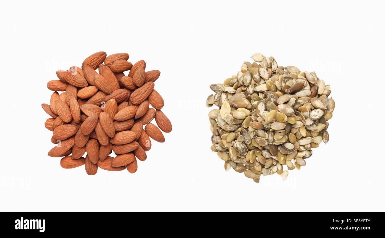 Pumpkin seeds and almonds in separate heaps Stock Photo