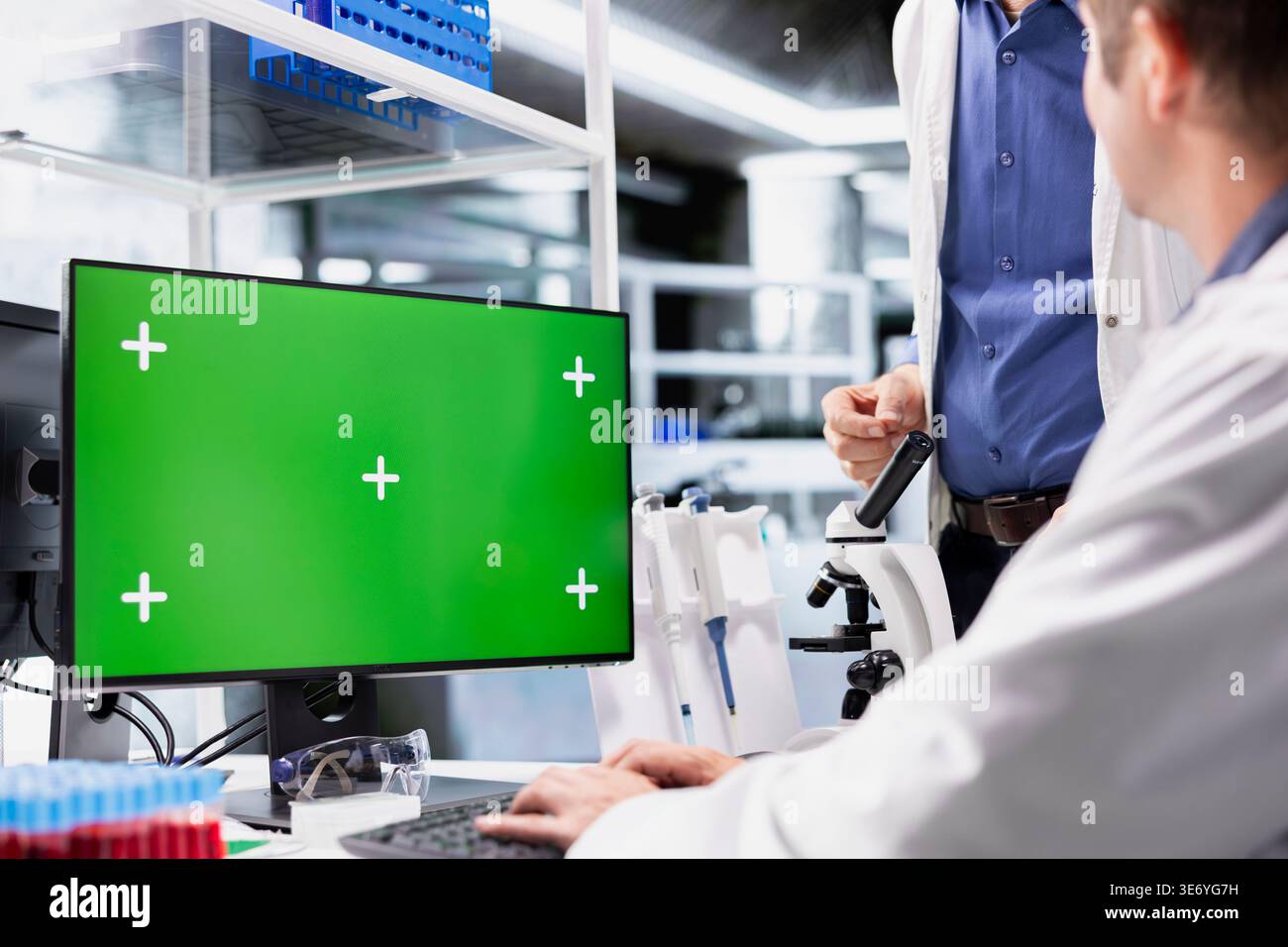 Green screen on desktop pc with two scientists working in chemistry lab, clinical research emphasizes molecular biology, healthcare innovation and biotechnology research for discovery. Stock Photo