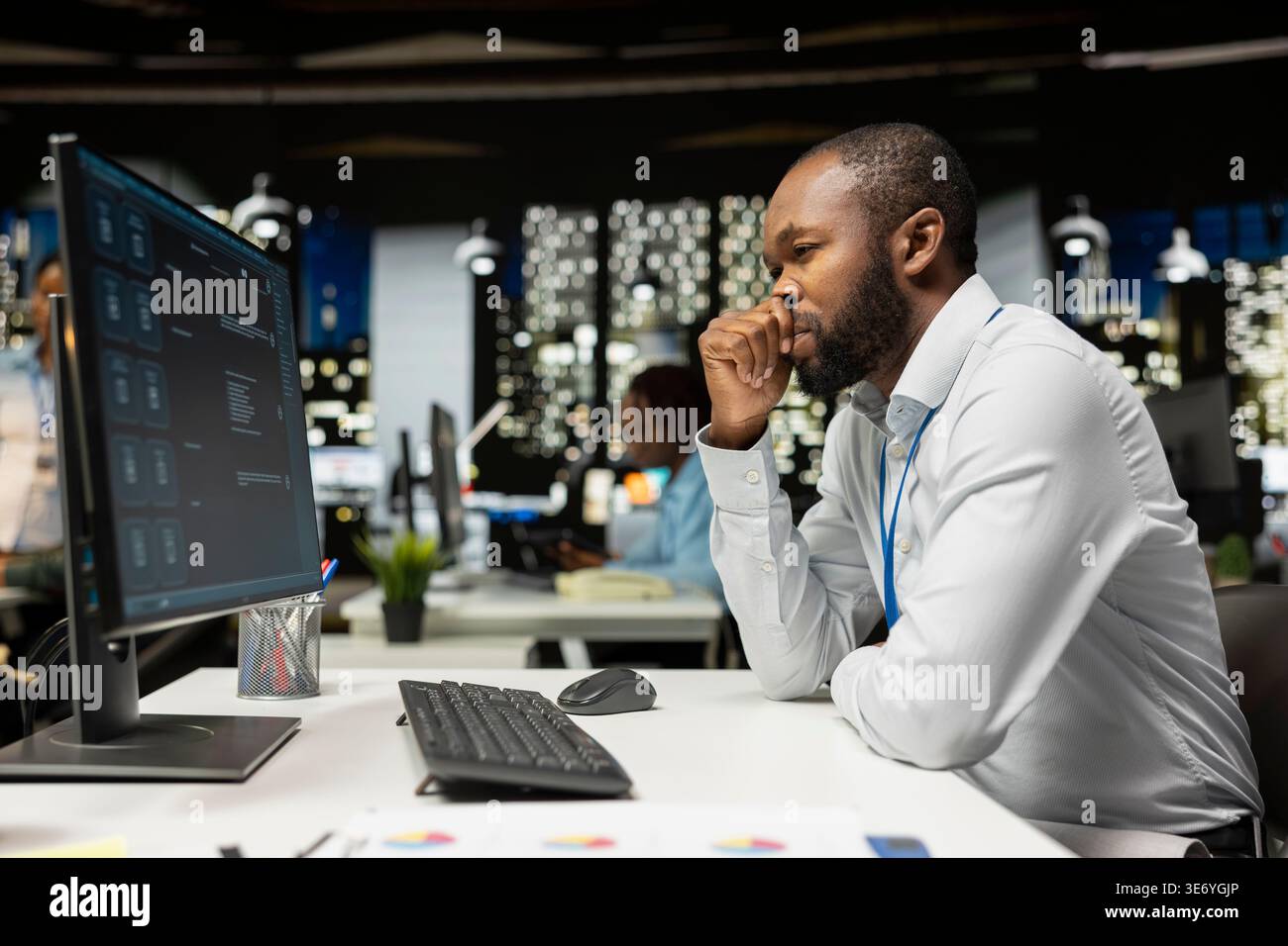 Black worker uses AI chatbot system at desktop for problem solving tasks, futuristic technology highlighting smart algorithms and machine learning. Communication and IT support. Stock Photo