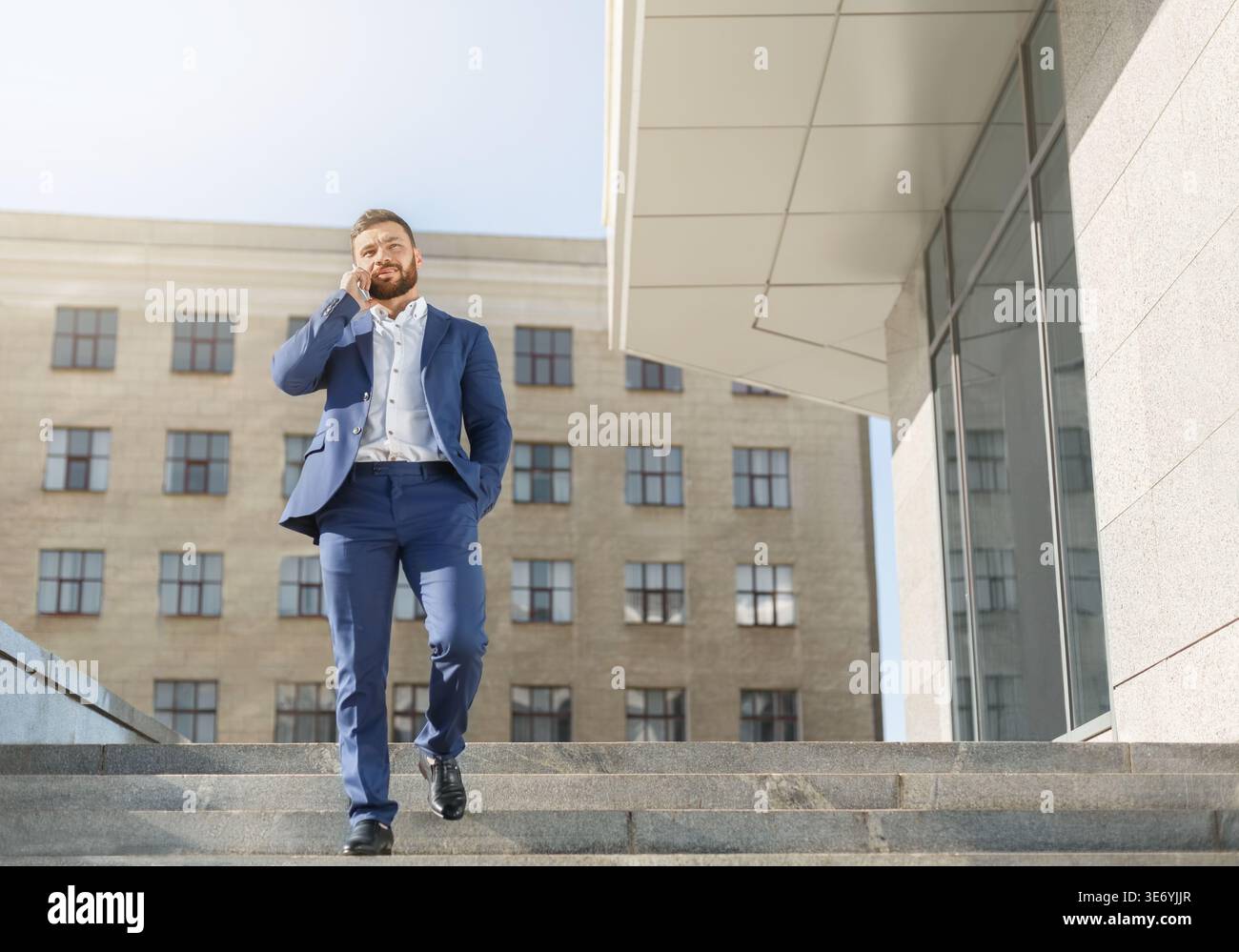 Businessman talking on mobile phone on walk Stock Photo