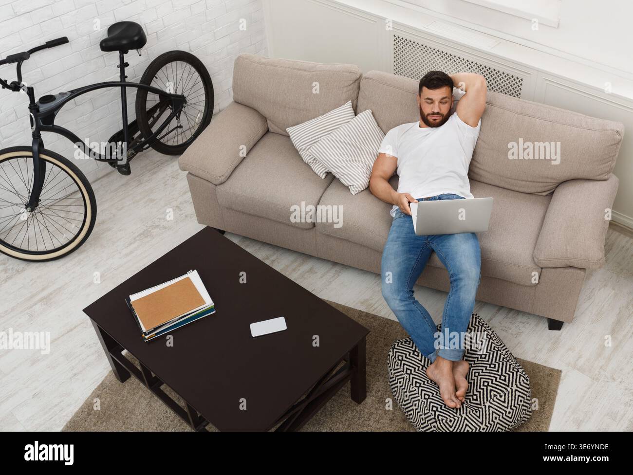Handsome man working on laptop at home Stock Photo