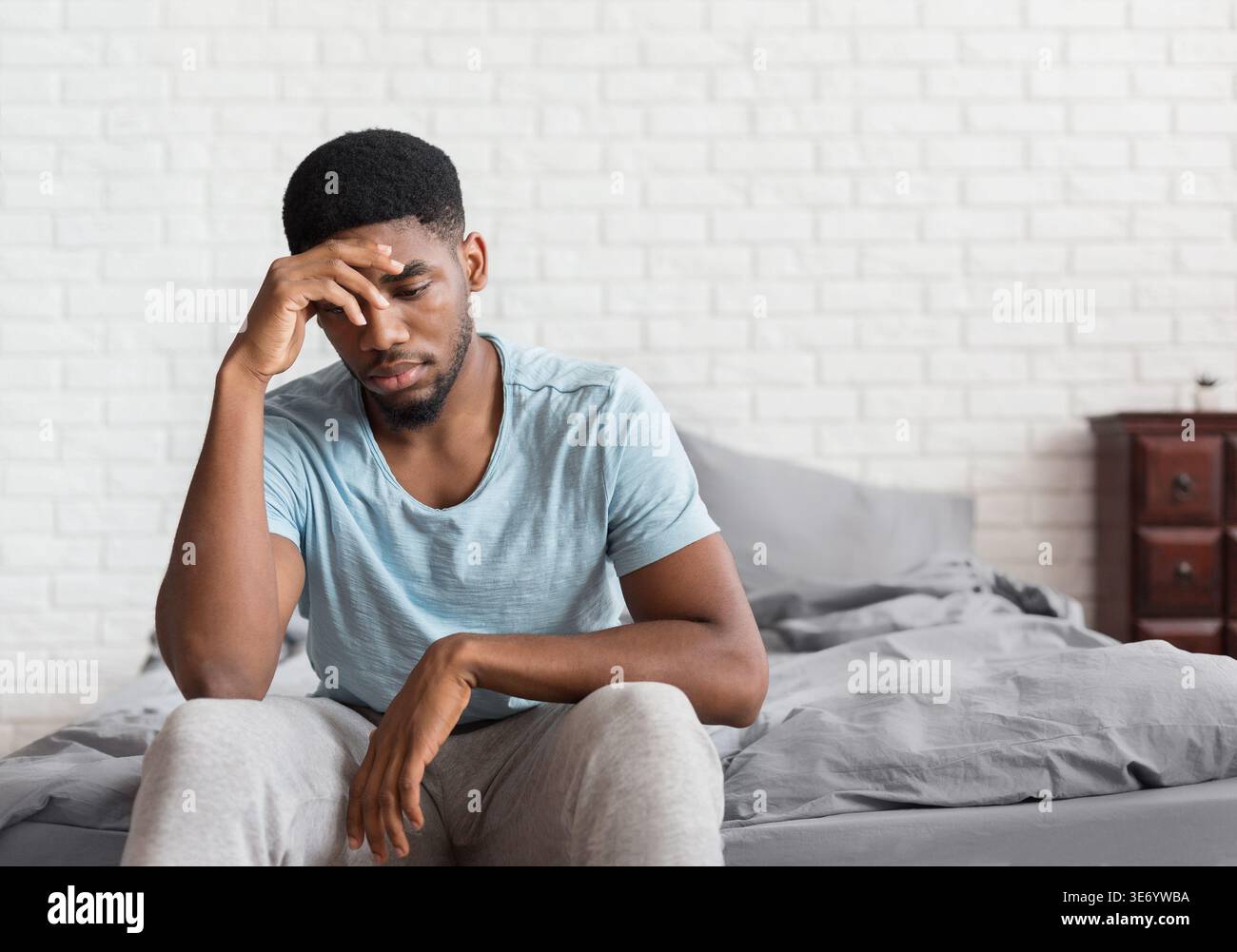 Young depressed black man sitting on bed Stock Photo