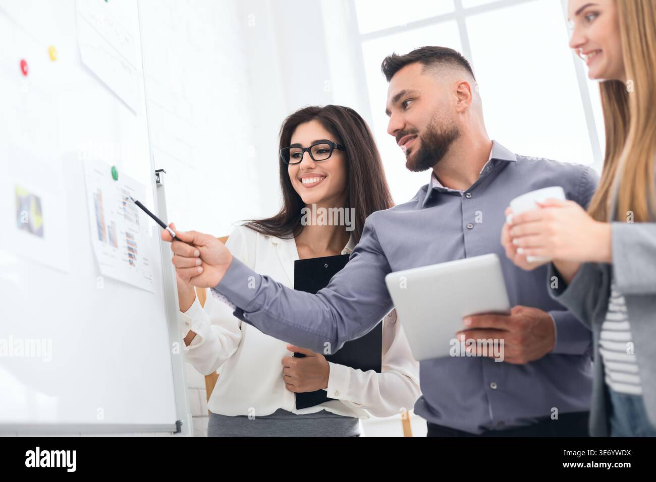 Discussing project together. Confident man showing graphics Stock Photo