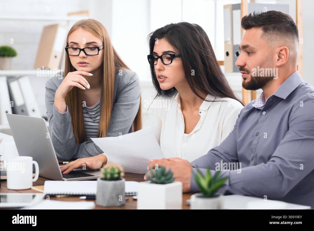 Concentrated business team with laptop and documents Stock Photo