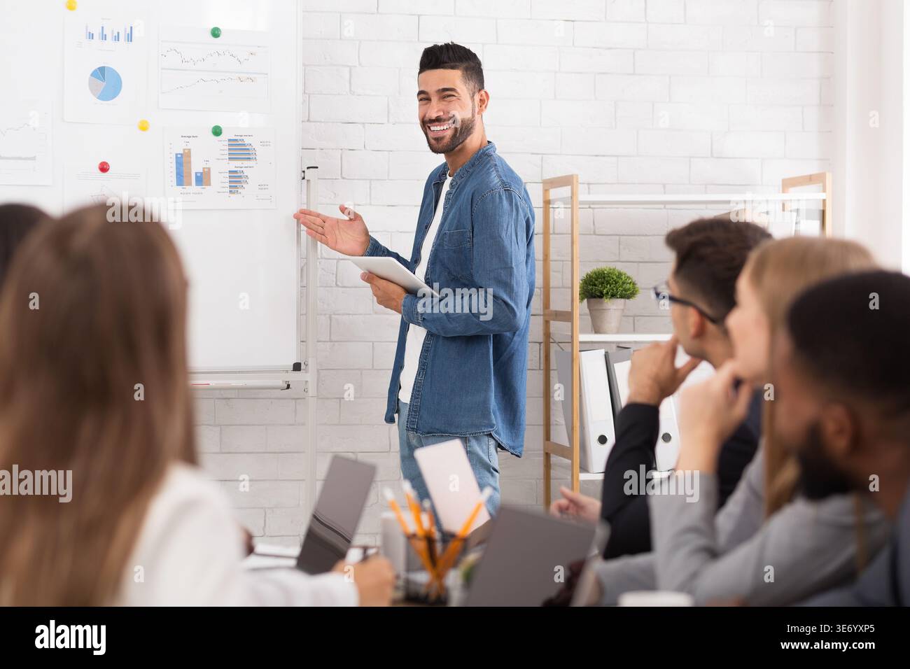 Business coach giving presentation to managers team Stock Photo