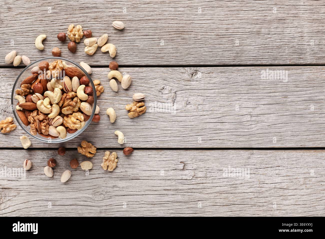 Bowl with mixed nuts on wooden table Stock Photo
