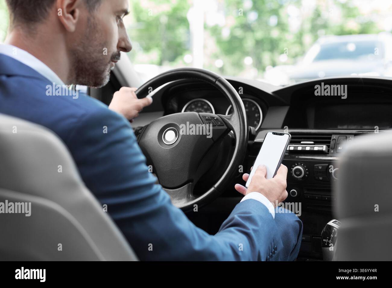 Businessman using mobile phone in traffic jam Stock Photo