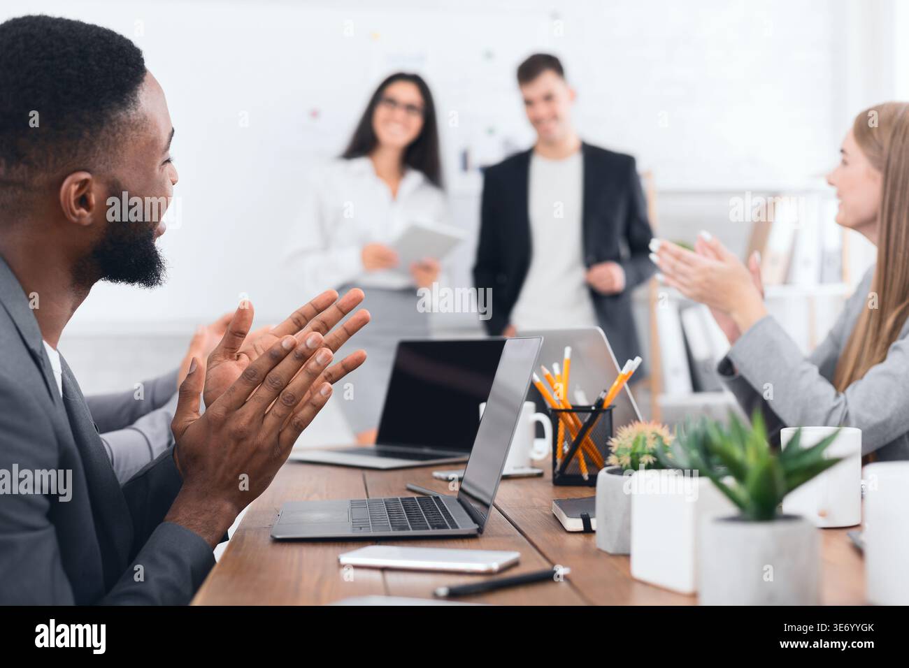 Business seminar. Colleagues clapping hands to speakers Stock Photo
