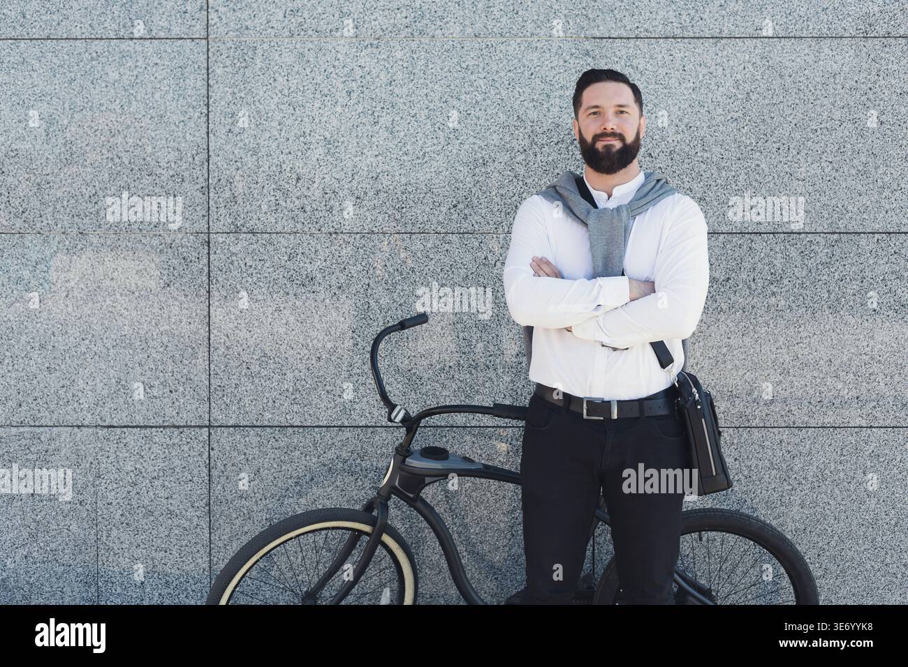 Modern ecologically friendly businessman posing near bicycle Stock Photo