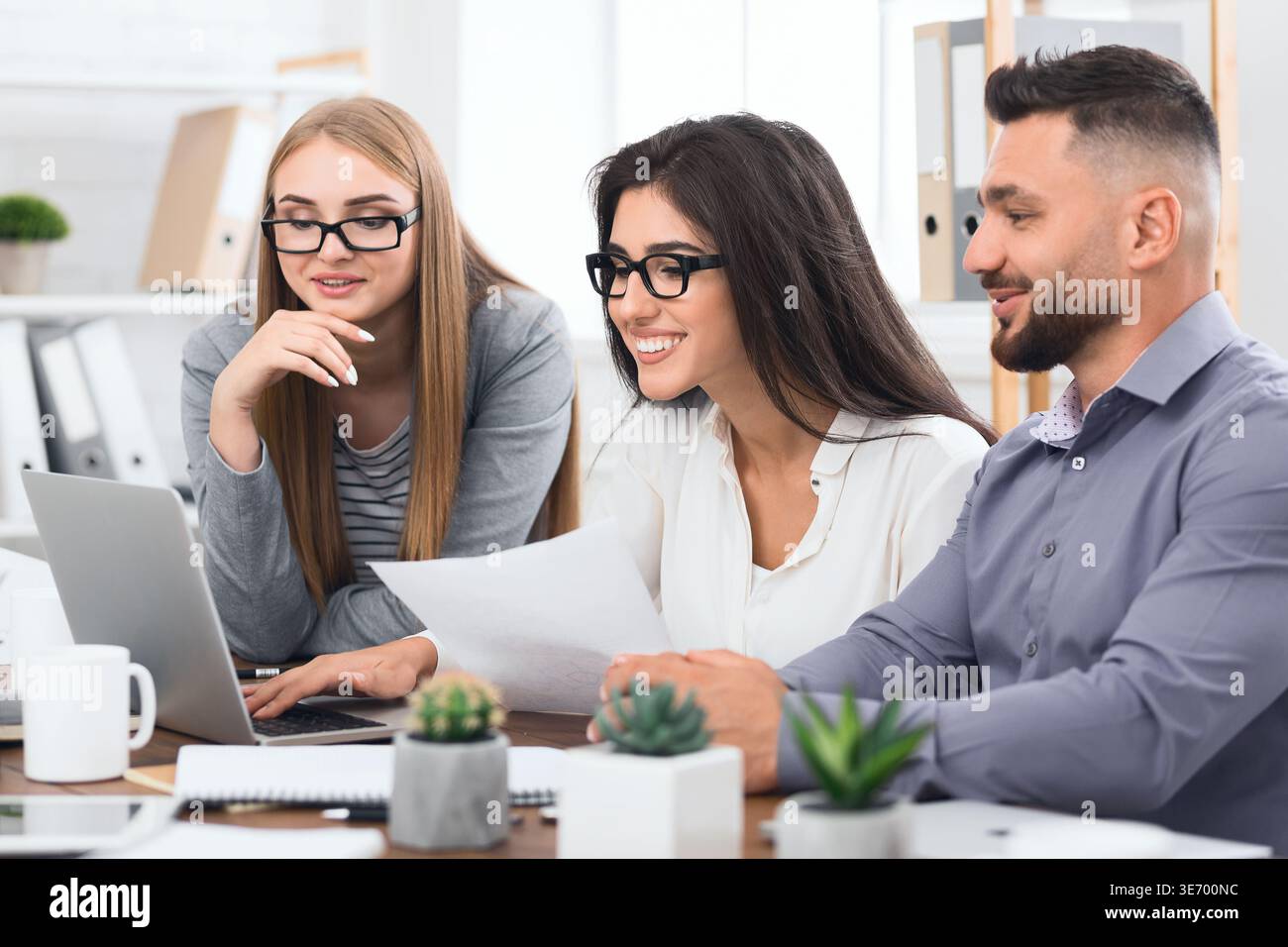Three designers working together on laptop in office Stock Photo