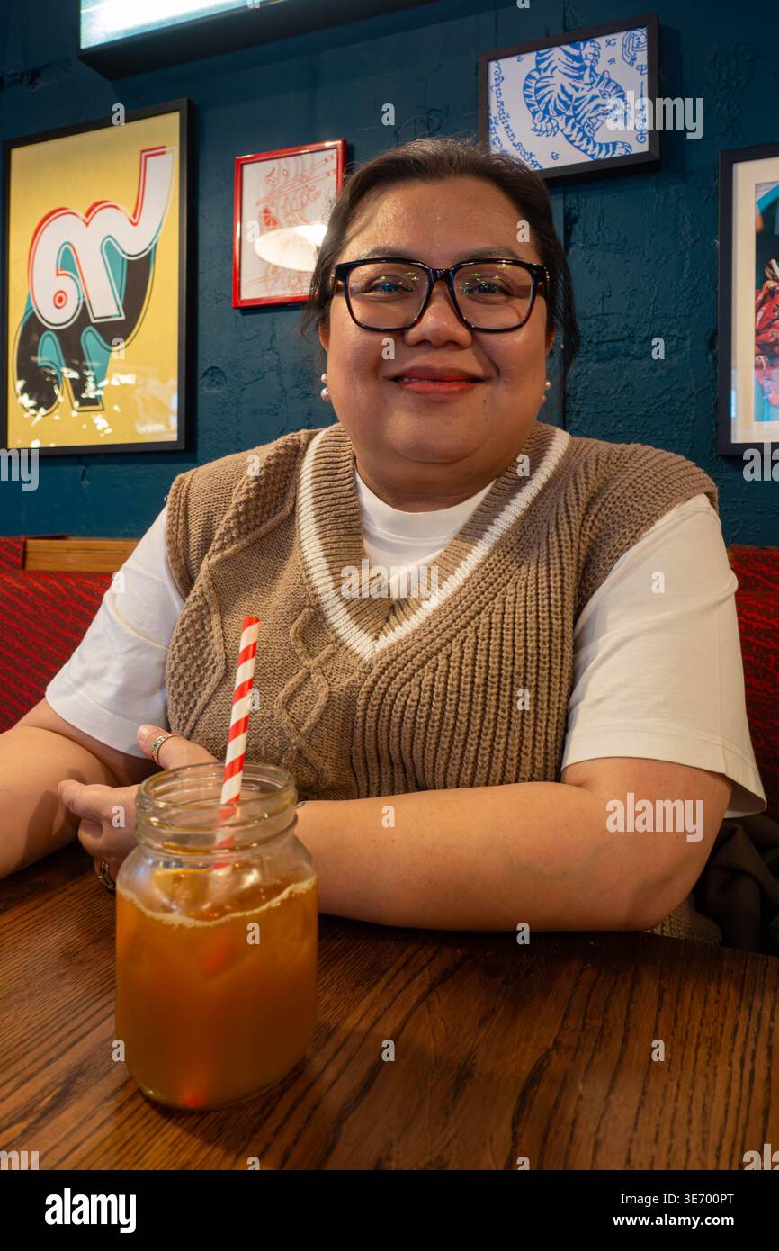 Portrait of a Filipino lady sat in a restaurant Stock Photo