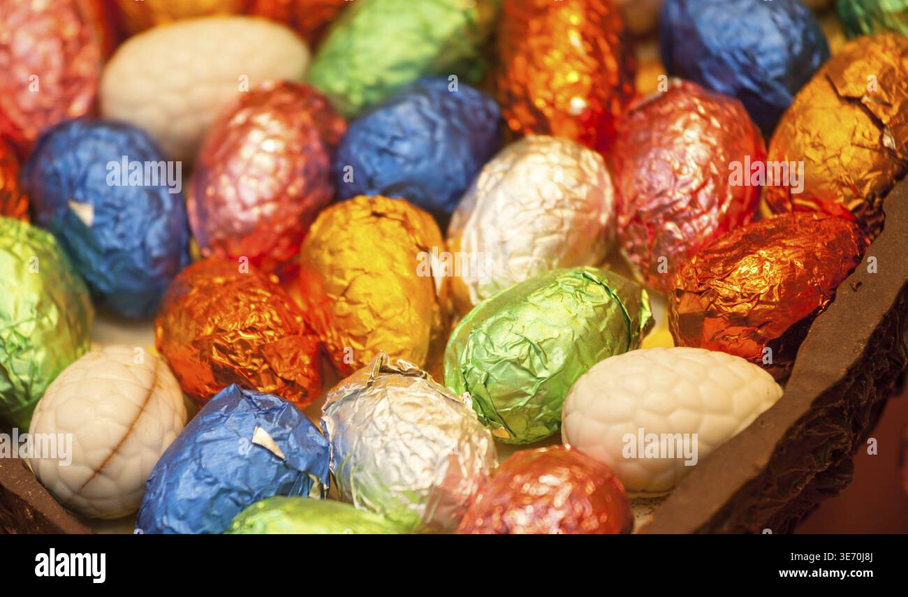 Multicolored foil wrapped easter eggs inside chocolate egg Stock Photo