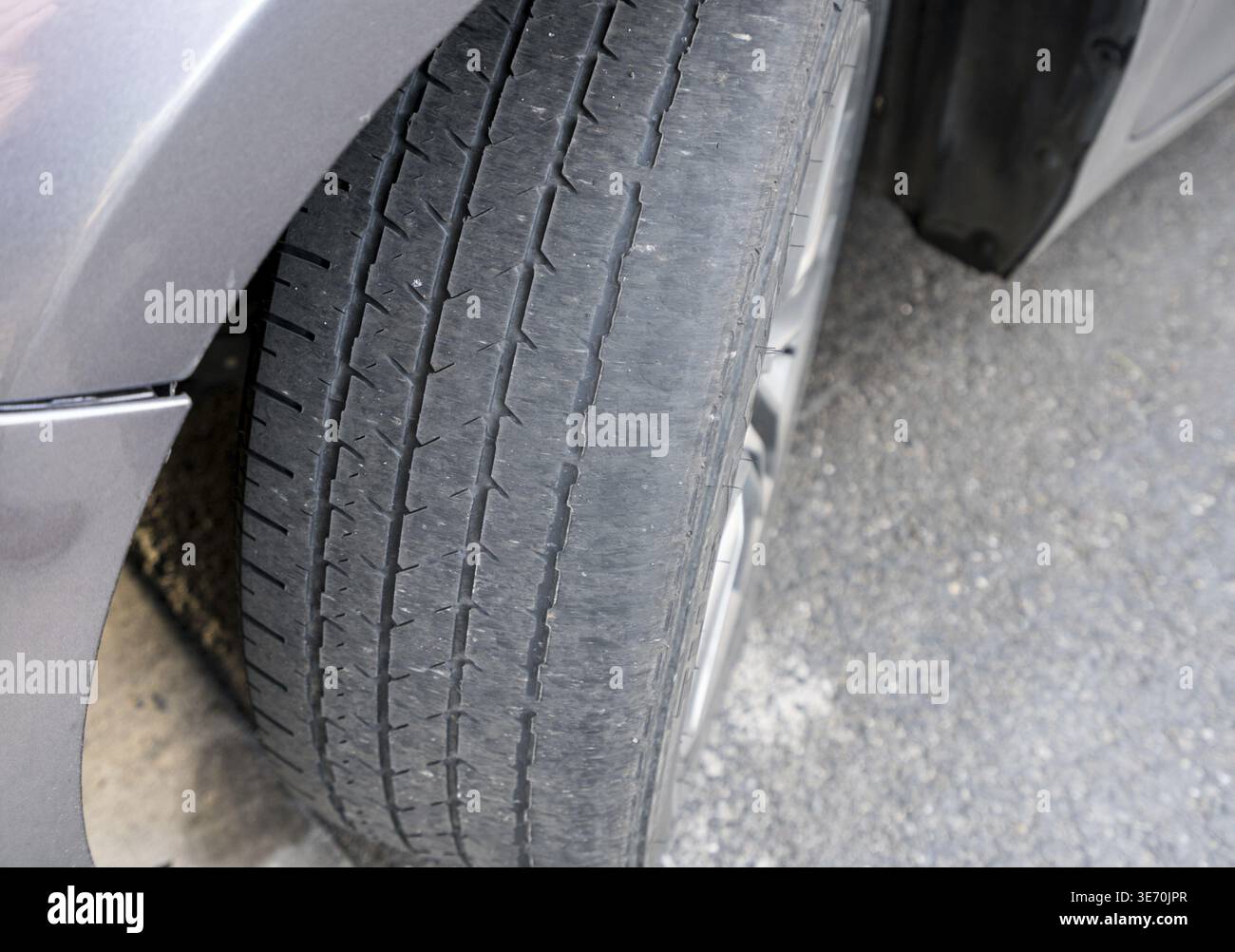 Front wheel tires or tyres on car badly worn and bald because of poor ...