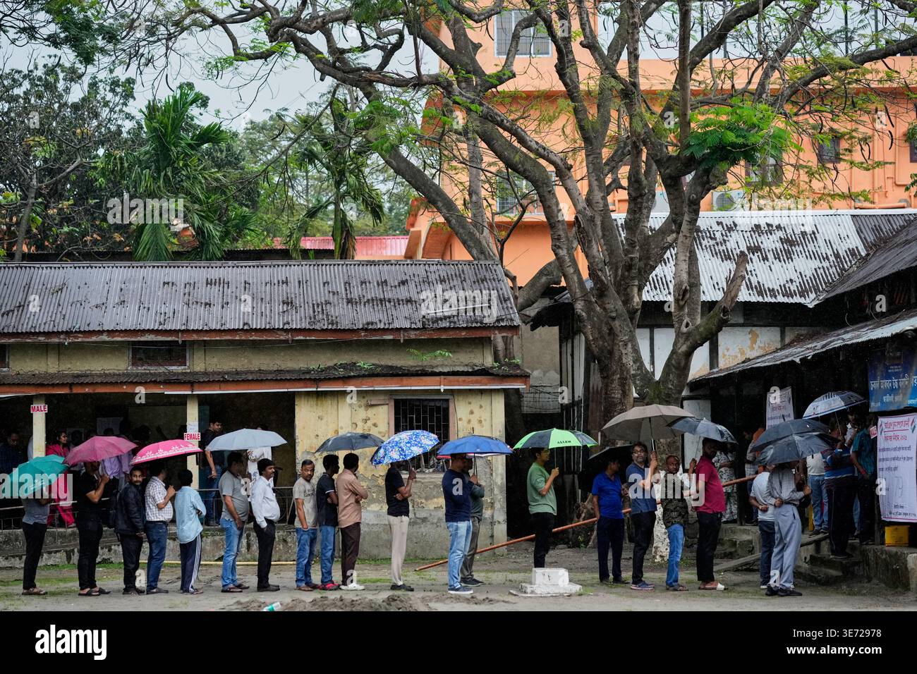 People stand in queue to cast their votes at a polling center during ...