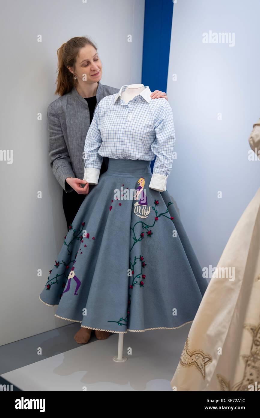 EDITORIAL USE ONLY A textile conservator adjusts a 'poodle' skirt on display as part of 'Queen Elizabeth II: Her Life in Style'. The largest exhibition of the Queen's fashion ever staged features EDITORIAL USE ONLY A textile conservator adjusts a 'poodle' skirt on display as part of 'Queen Elizabeth II: Her Life in Style'. The largest exhibition of the Queen's fashion ever staged features