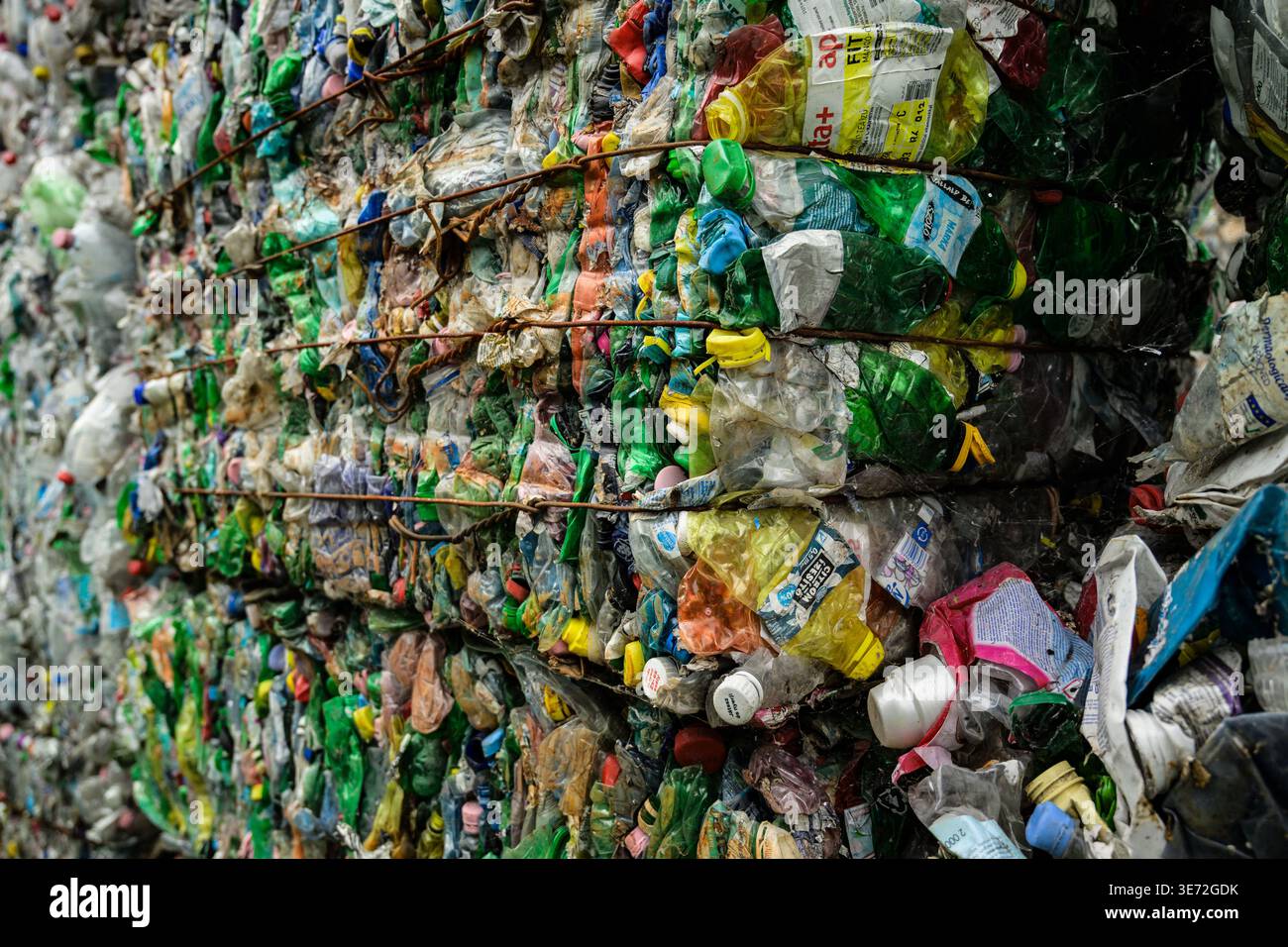 Compressed bales of crushed plastic bottles ready for recycling and reuse Stock Photo