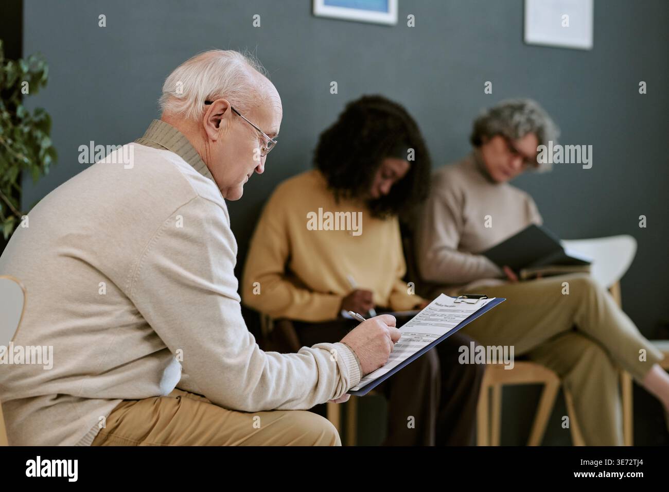 Senior Man Completing Intake Form in Group Therapy Session Stock Photo