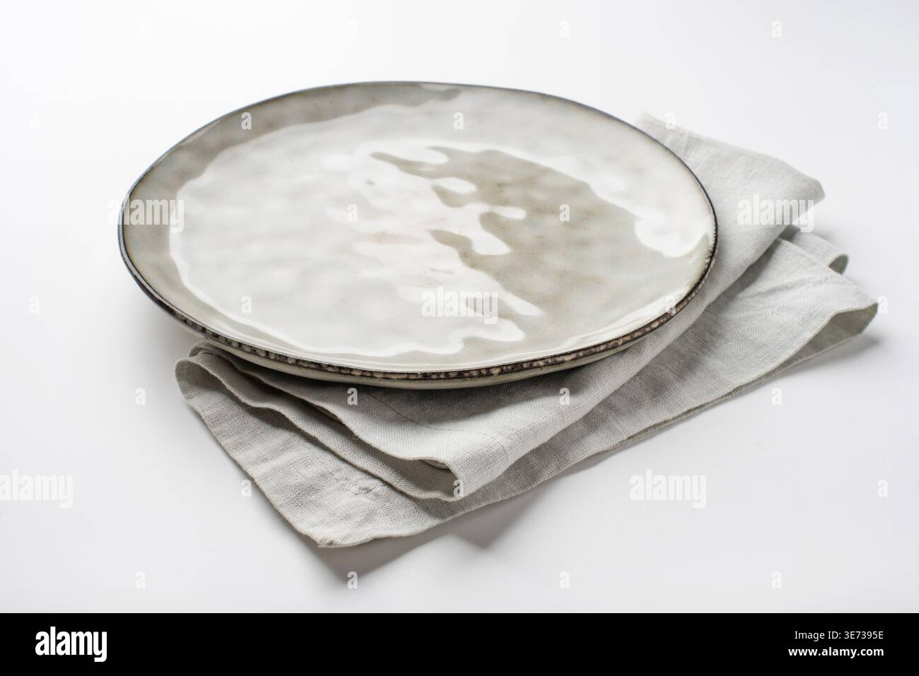 An empty grey textured plate on a white table Stock Photo