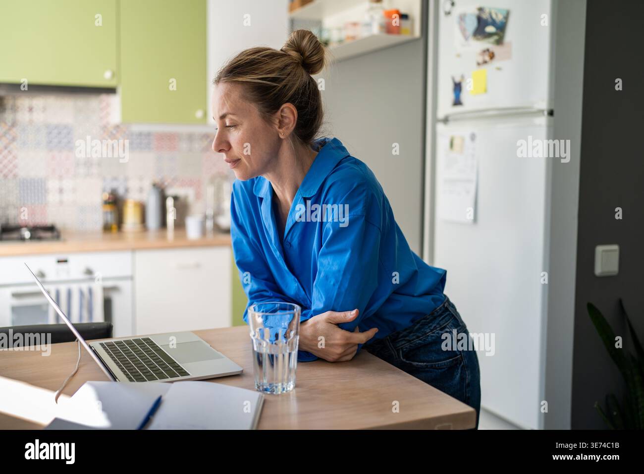 Interested smiling mature woman watching media online on laptop, looking through viral content. Stock Photo