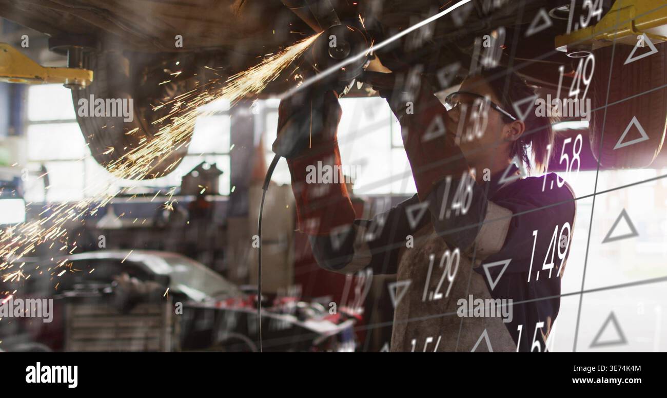 Grinding mechanic using angle grinder under lift in garage, gloves sparks, data overlay, copy space. Undercarriage, workshop, grind, arcs, daylight, i Stock Photo