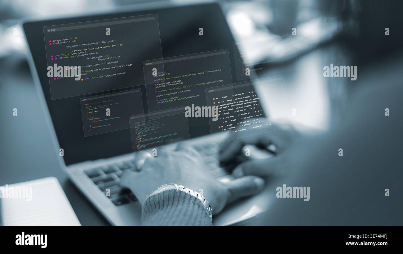 Software developer working on laptop with code overlay.Programmer hands typing on computer keyboard in dark office.Digital transformation and software Stock Photo