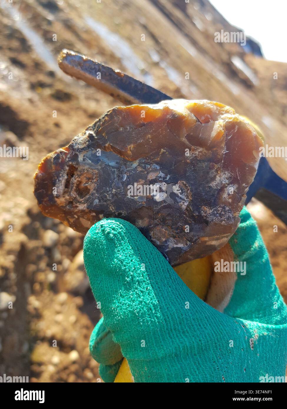 Hand holding a rugged, translucent piece of chalcedony flint rock ...