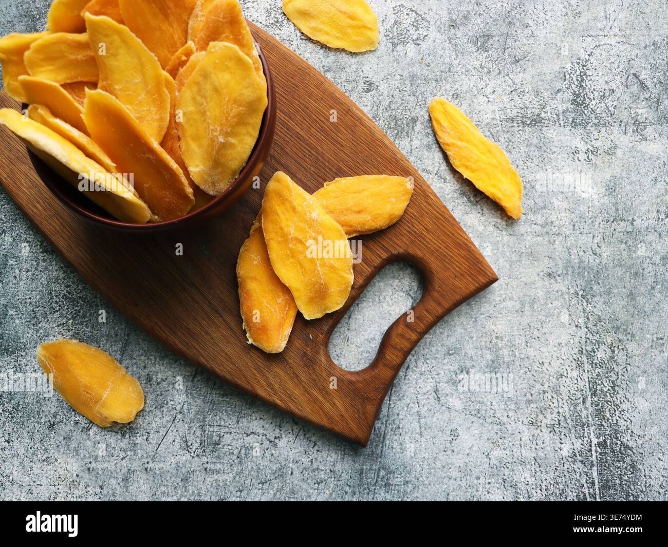 Dried Mango Slices on Wooden Board Stock Photo