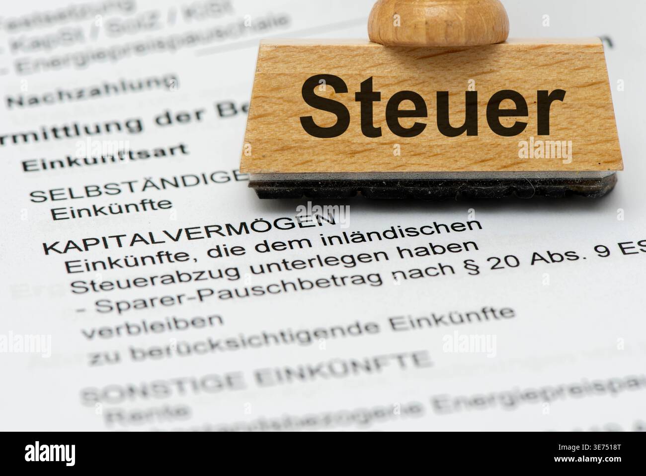 Steuer auf Kapitalvermögen Ein Holzstempel ist beschriftet mit dem Aufdruck Steuer als Symbolbild für Steuern über Kapitalvermögen an das Finanzamt - Stock Photo