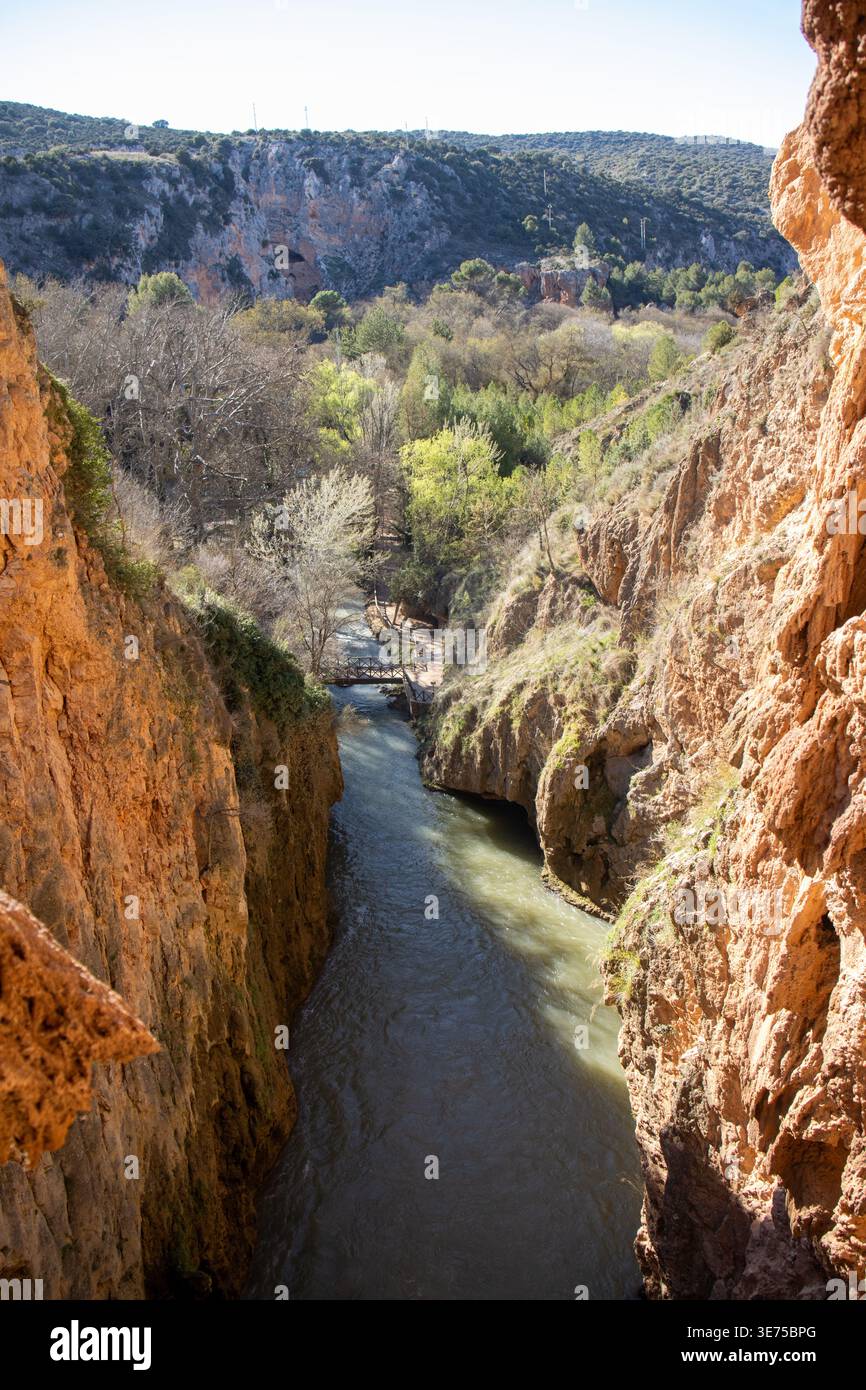 Cañón rocoso con el río fluyendo entre paredes escarpadas en el Parque Natural del Monasterio de Piedra. Vegetación y puente de madera. España Stock Photo