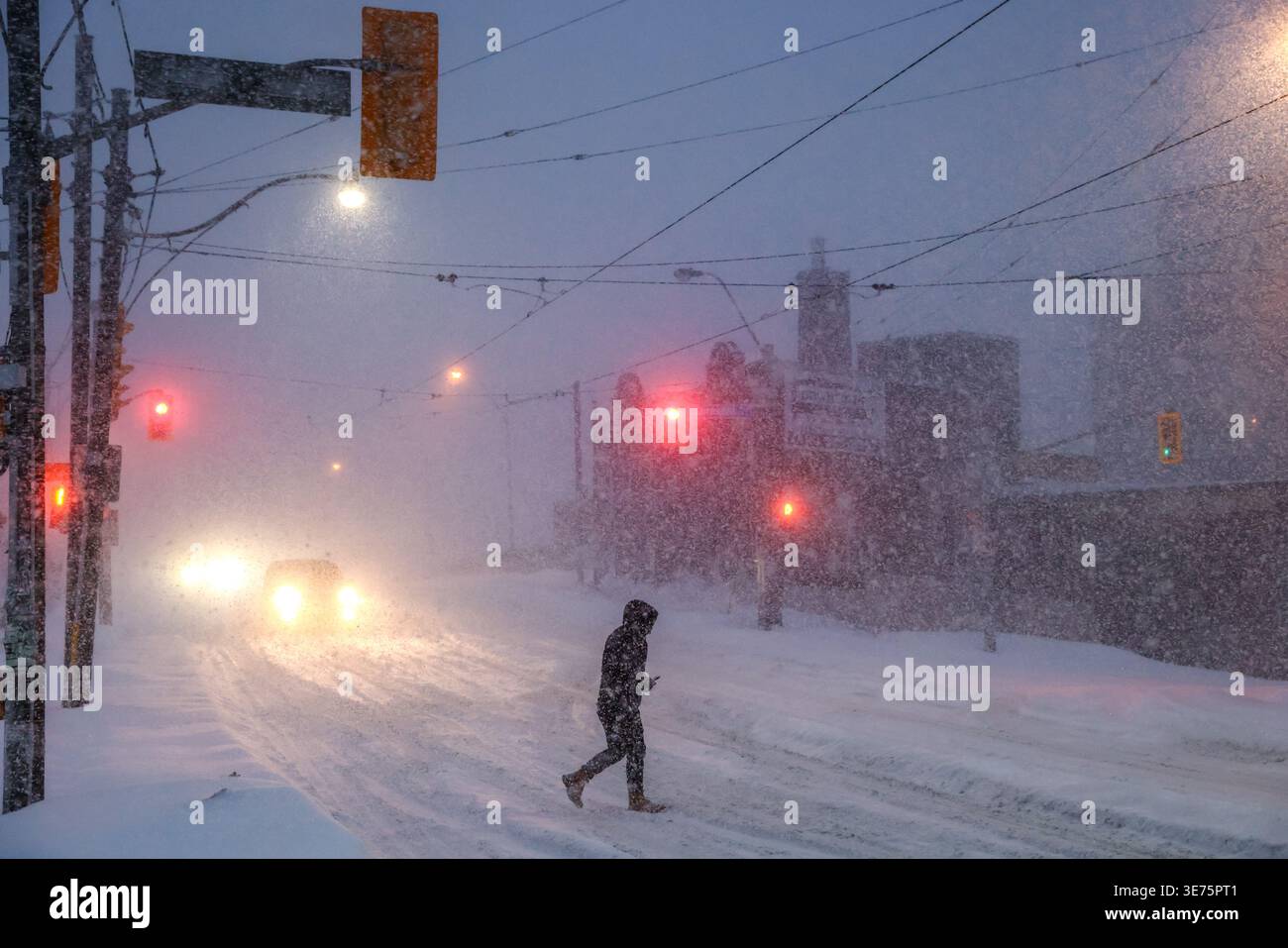 People walk through downtown Toronto during a winter storm on Sunday ...