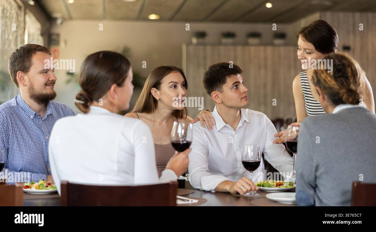 Female waitress taking order from group of friends in restaurant Stock Photo